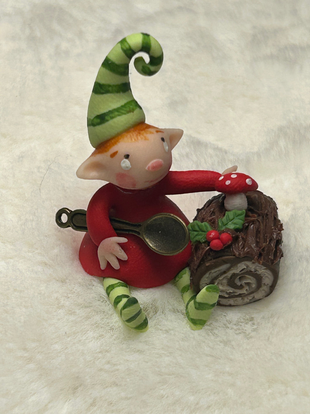 Pequeño duende navideño con su tronco de Navidad
